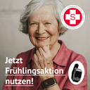 Ältere Frau lächelt und trägt eine SOS-Armbanduhr. Frühlingsaktion nutzen!