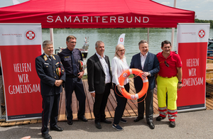 Die Präsidentin vom Samariterbund und 6 Männer vom Samariterbund posieren für ein Foto bei der Bootseinweihung.