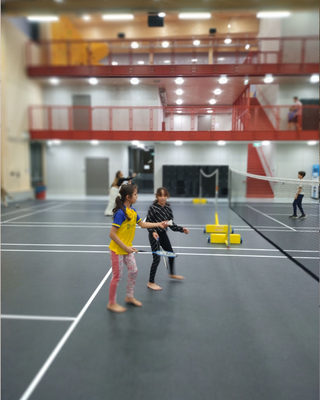 Zwei Mädchen spielen Badminton.