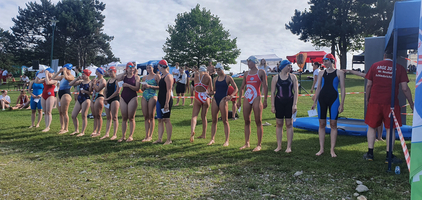 Gruppierung von Schwimmerinnen, die sich für einen Wettkampf vorbereiten.