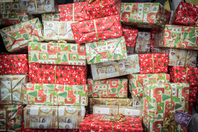 Vielzahl von festlich verpackten Geschenken in verschiedenen Farben und Mustern.