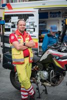 Ein Sanitäter in Warnkleidung steht neben einem Rettungsmotorrad.