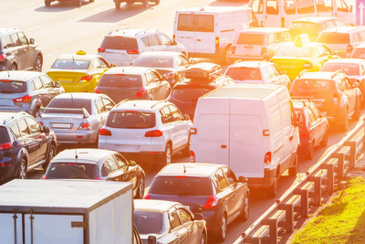 Stau mit vielen Autos auf einer sonnigen Straße.