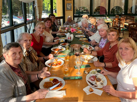 Eine Gruppe von Personen sitzt an einem Tisch und genießt ein gemeinsames Essen.