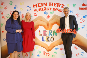 V. l. Barbara Nowak, Susanne Drapalik und Oliver Löhlein posieren vor dem DIF-Hintergrund mit Hashtag DIF24
