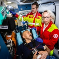 Sanitäterin mit Patienten im Rettungswagen, Samariterbund-Kollege im Hintergrund