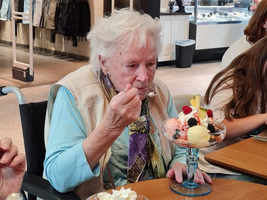 Eine ältere Frau isst Eis in einem Café.