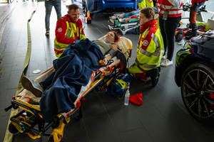 Rettungskräfte kümmern sich um eine verletzte Person auf einer Trage.