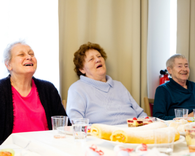 Drei Bewohner:innen unserer Senioren-WGs beim gemeinsamen Kuchenessen.
