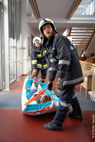 Feuerwehrleute mit Patient auf Trage