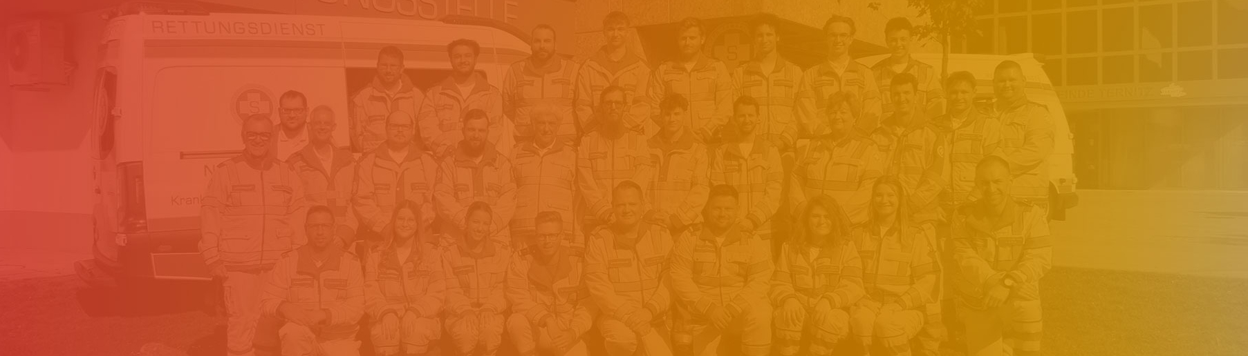 Gruppenfoto von Rettungsdienstmitarbeitern vor einem Einsatzfahrzeug.