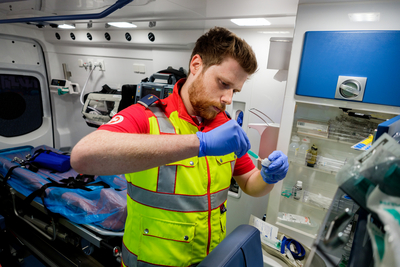 Ein Sanitäter bereitet eine Behandlung im Inneren eines Rettungswagens vor.
