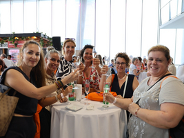 Sechs Frauen stoßen mit Gläsern auf ein erfolgreiches Ereignis an.