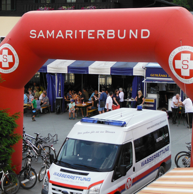 Ein roter Bogen mit dem Schriftzug „Samariterbund“ über einer Veranstaltung.