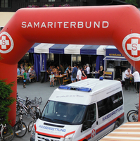 Ein roter Bogen mit dem Schriftzug „Samariterbund“ über einer Veranstaltung.