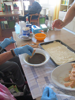Person dippt einen Keks in eine Schüssel mit dunkler Flüssigkeit zum Backen.