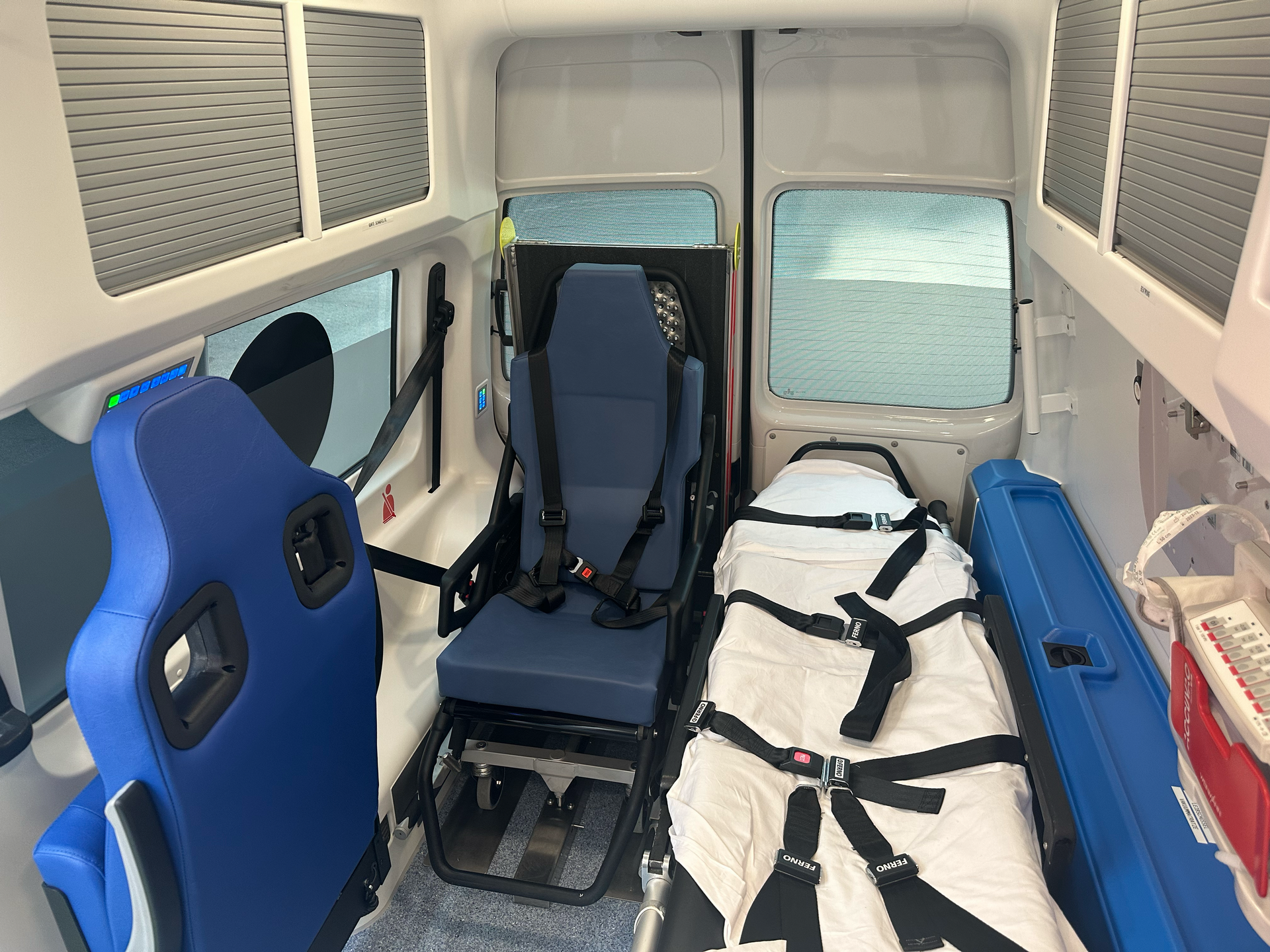 Innenansicht eines Krankenwagens mit einem Sitz und einer Trage.