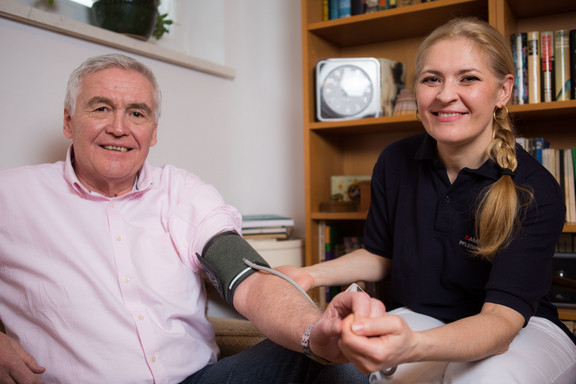 Betreuerin misst Blutdruck bei einem Klienten 