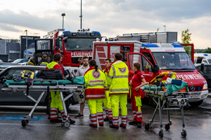 Rettungskräfte besprechen Einsatz vor zwei Krankenwagen und einer Feuerwehrauto.