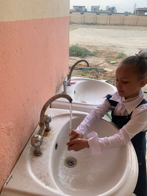 Mädchen wäscht sich die Hände in einem Waschbecken