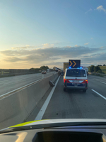 Polizei steht mit Fahrzeug auf der Autobahn, um einen Unfall zu sichern.