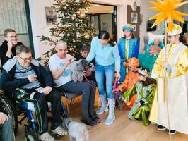 Besuch von Kindern und Tieren in einem weihnachtlich geschmückten Raum.