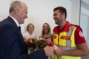 Menschen lachen und feiern einen Moment der Wertschätzung mit Blumen und Geschenken.