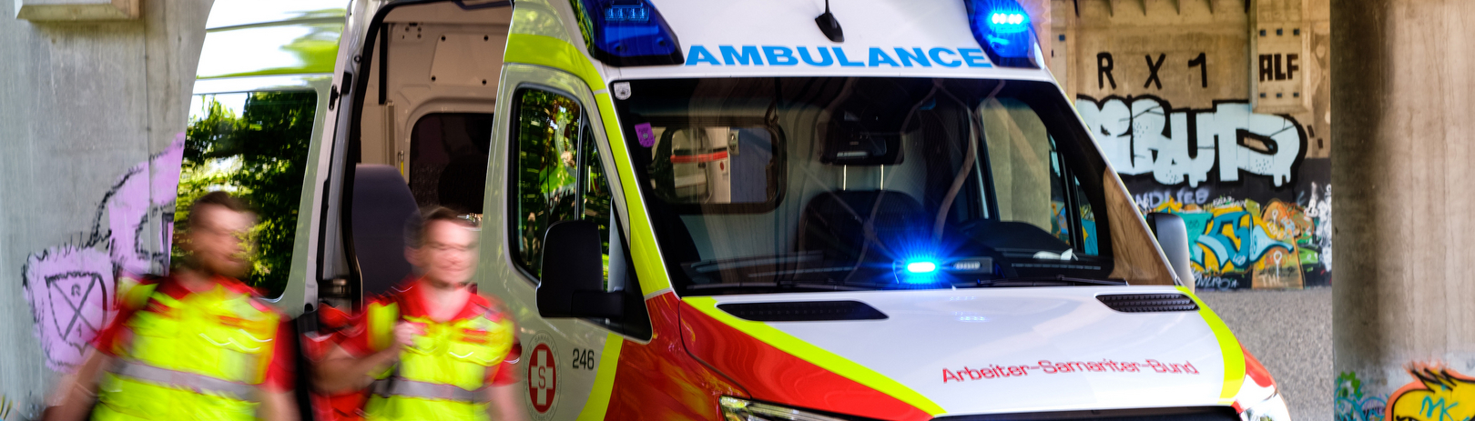 Zwei Samariterbund-Sanitäter vor Rettungswagen