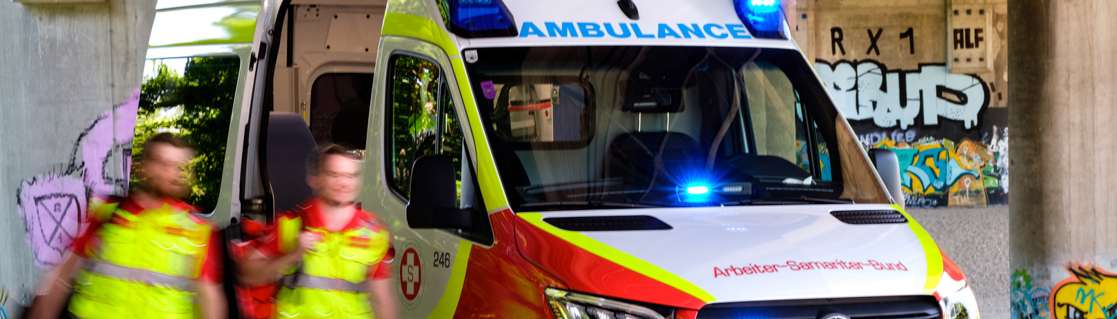 Zwei Samariterbund-Sanitäter vor Rettungswagen