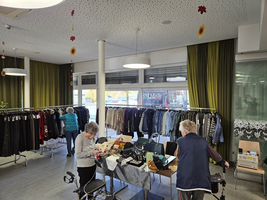 Zwei ältere Frauen durchsuchen Kleidung in einem Geschäft. Veränderungen von Herbstmode sichtbar.