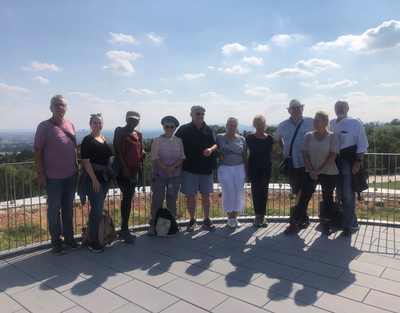 Gruppe an Leuten auf Aussichtsplattform in Wien, blauer Himmel mit einzelnen Wolken
