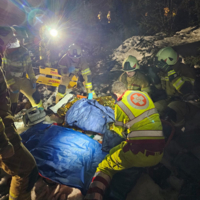 Rettungsteam hilft einer Person in einer verschneiten Umgebung.