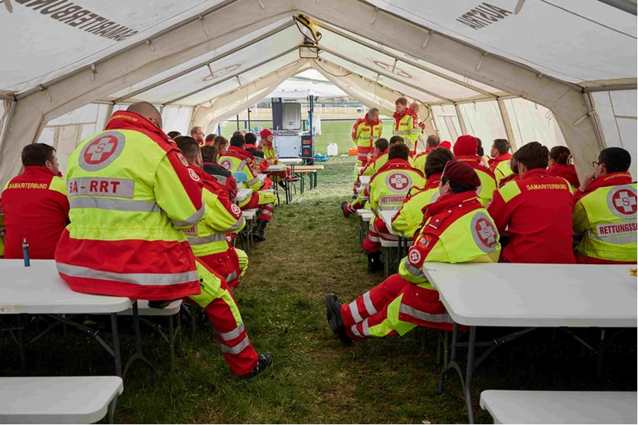 SA-RRT-Mitglieder sitzen auf Feldbetten in einem Zelt für Lagebesprechung